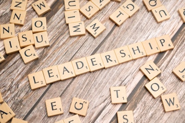 scrabble tiles spelling out the word leadership on a wooden surface