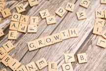 scrabbled letters spelling growth on a wooden surface