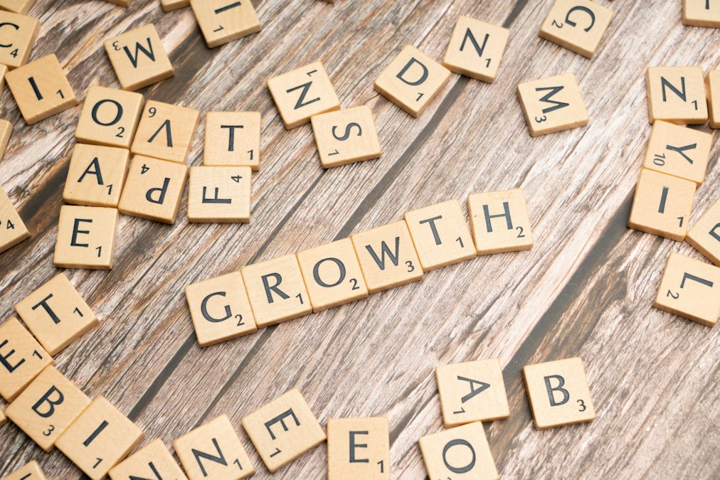 Wooden letter tiles spelling 'growth' on a warm wood surface