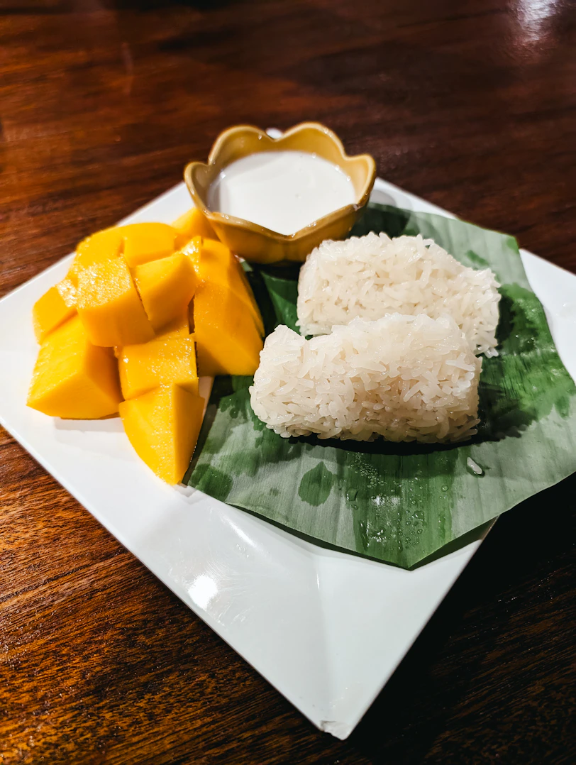 a plate of food with rice, mango and sauce