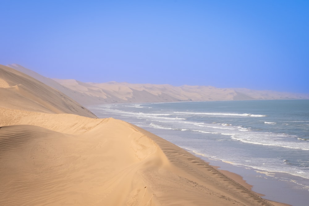 a sandy beach with a body of water in the distance