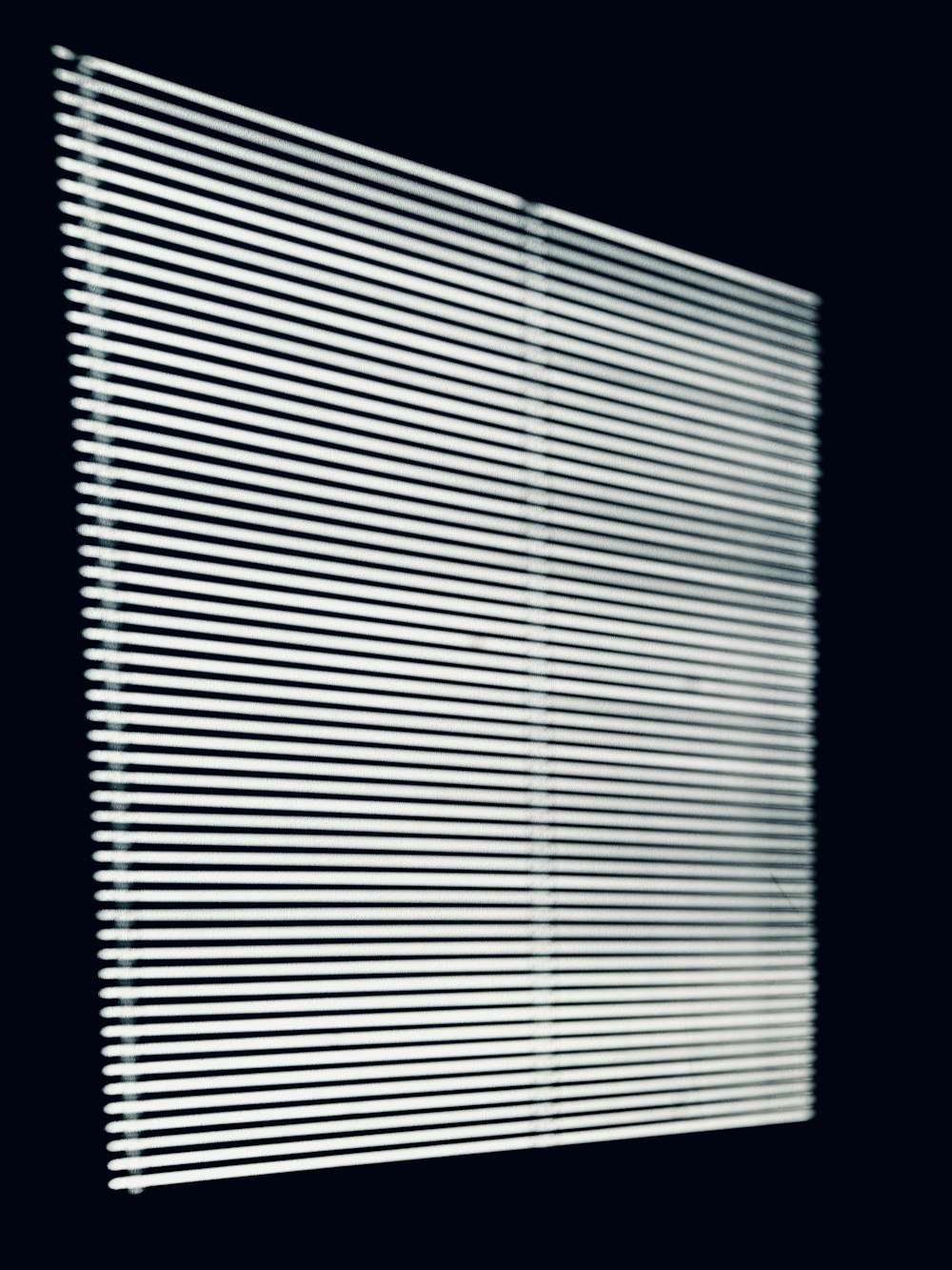 une photo en noir et blanc d’une fenêtre avec des stores