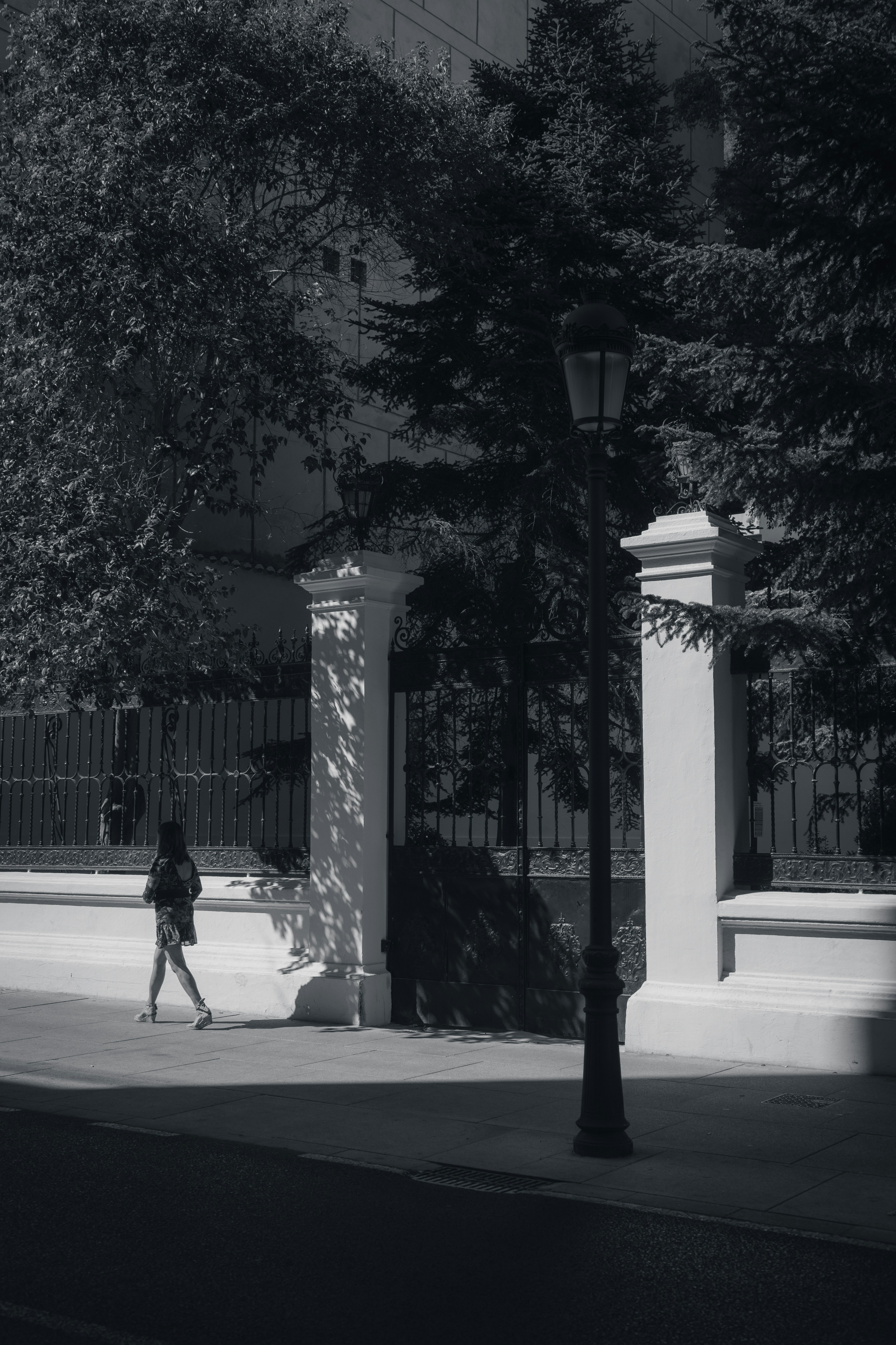 a person walking down a sidewalk next to a tall building