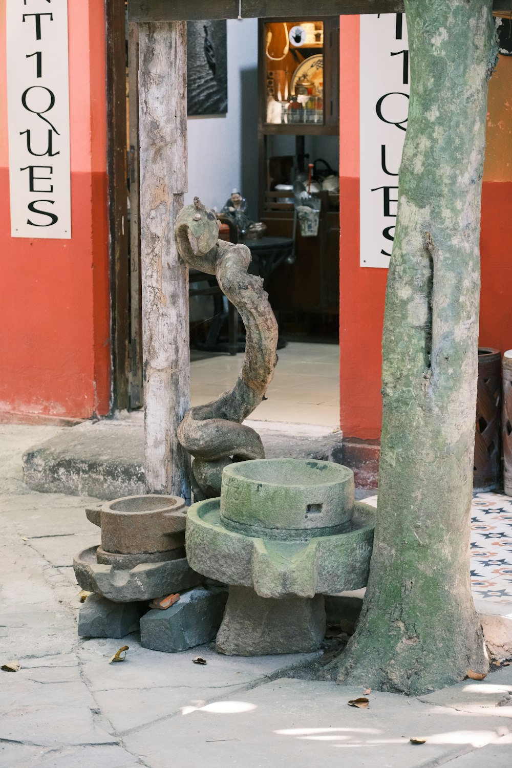 a stone fountain in front of a tree