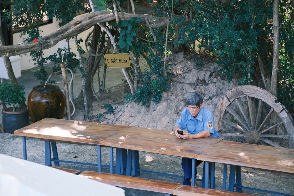a man sitting at a table using a cell phone