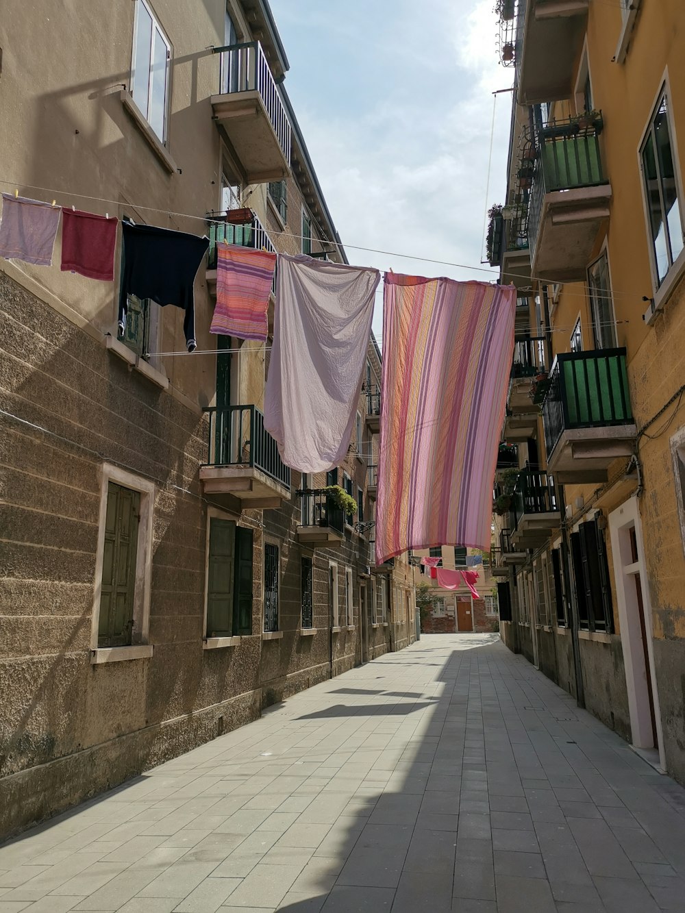 a city street lined with buildings and laundry hanging from a line