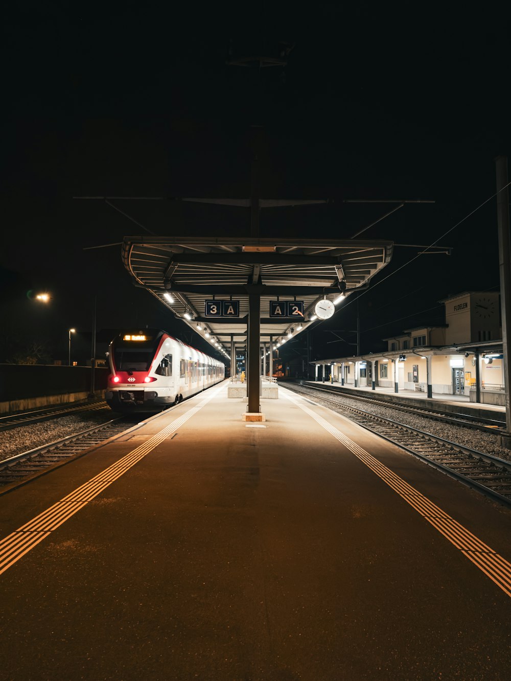 a train pulling into a train station at night