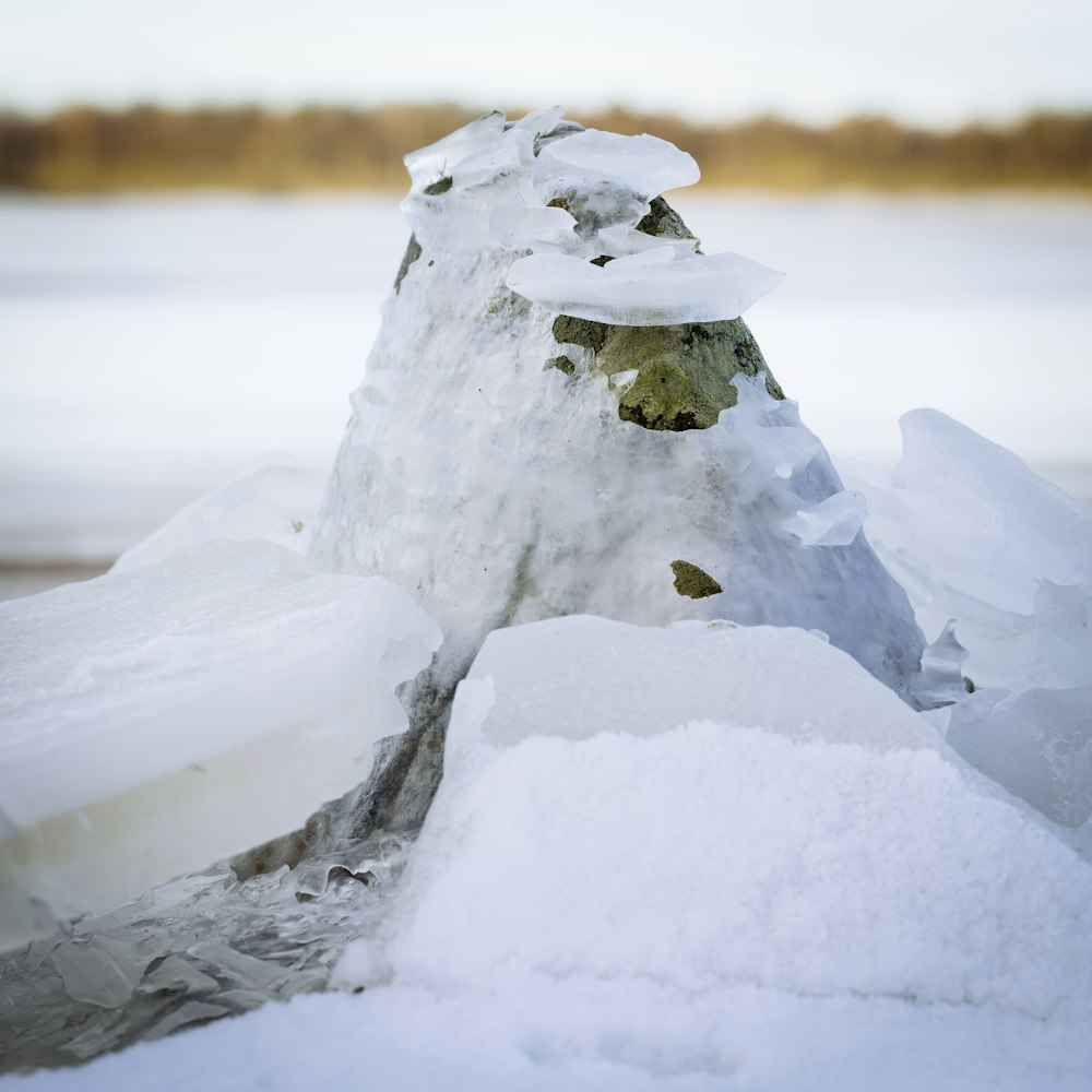 a pile of snow sitting next to a body of water