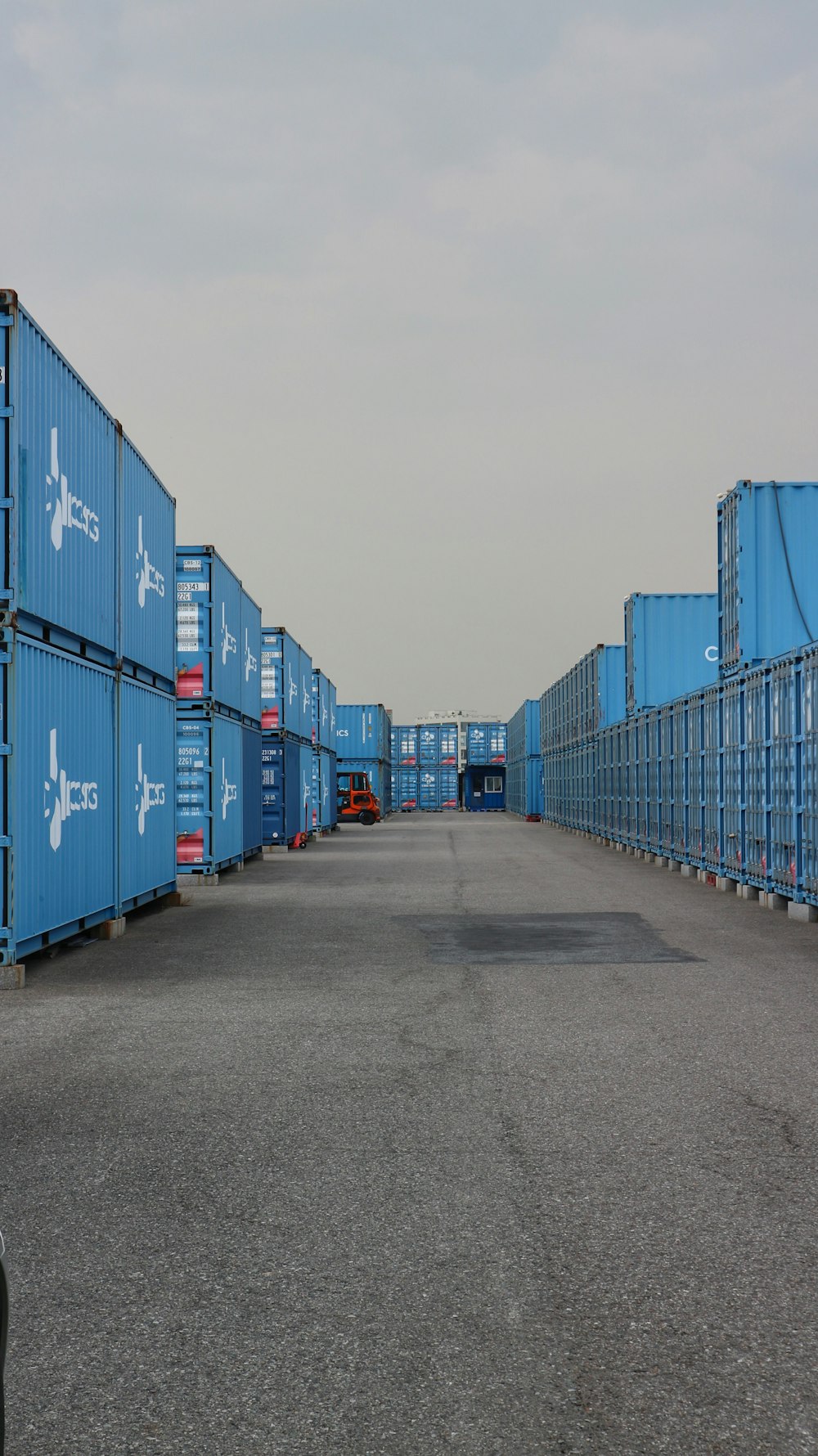 a row of blue shipping containers sitting next to each other