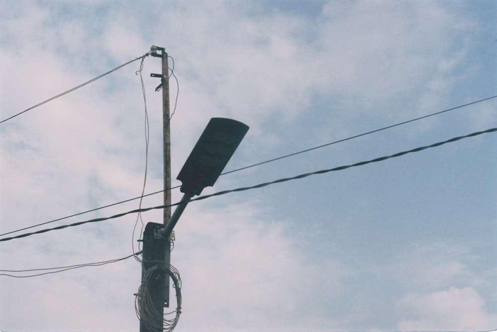 a telephone pole with wires and a sky background