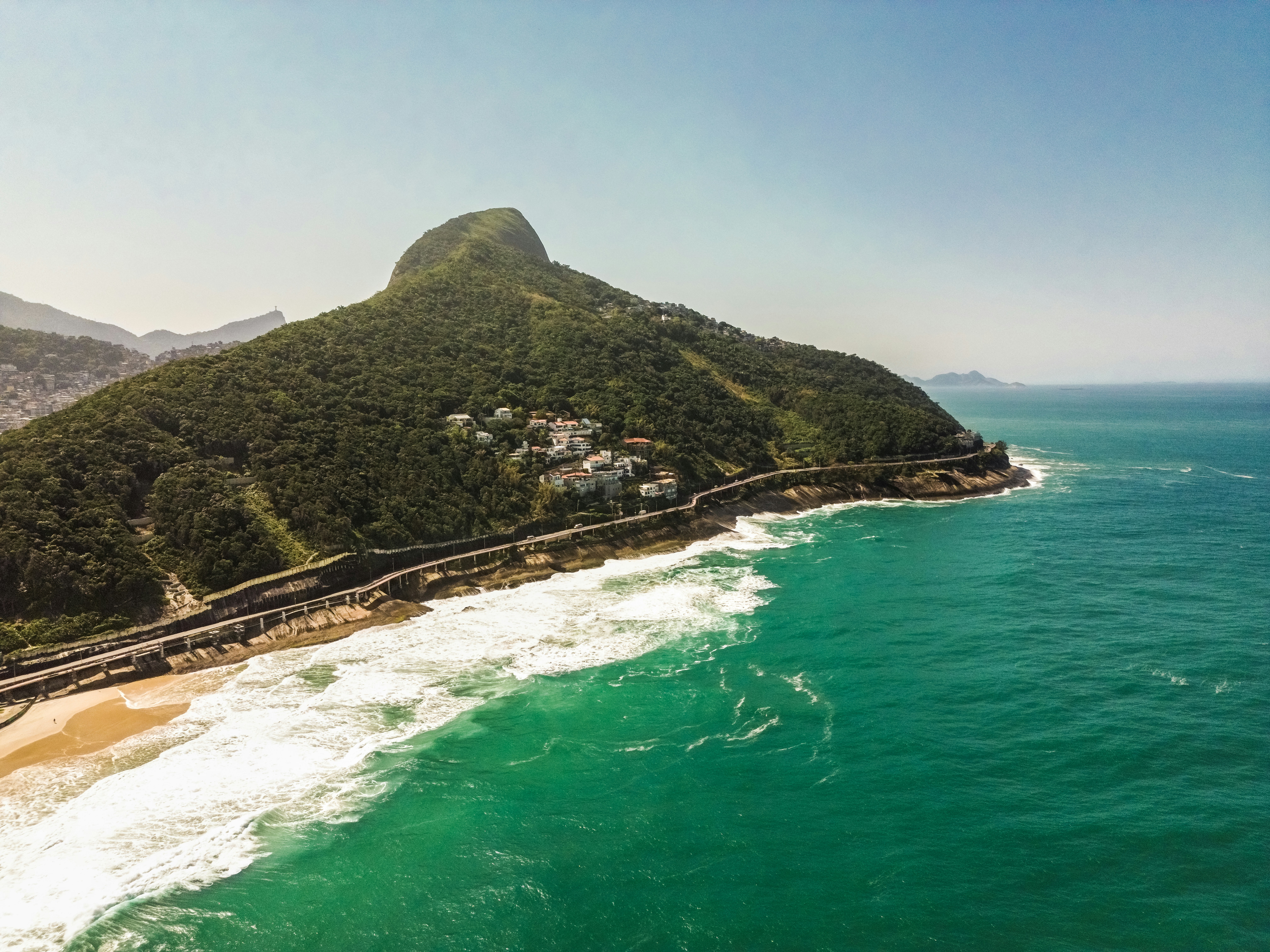 an aerial view of a beach with a mountain in the background