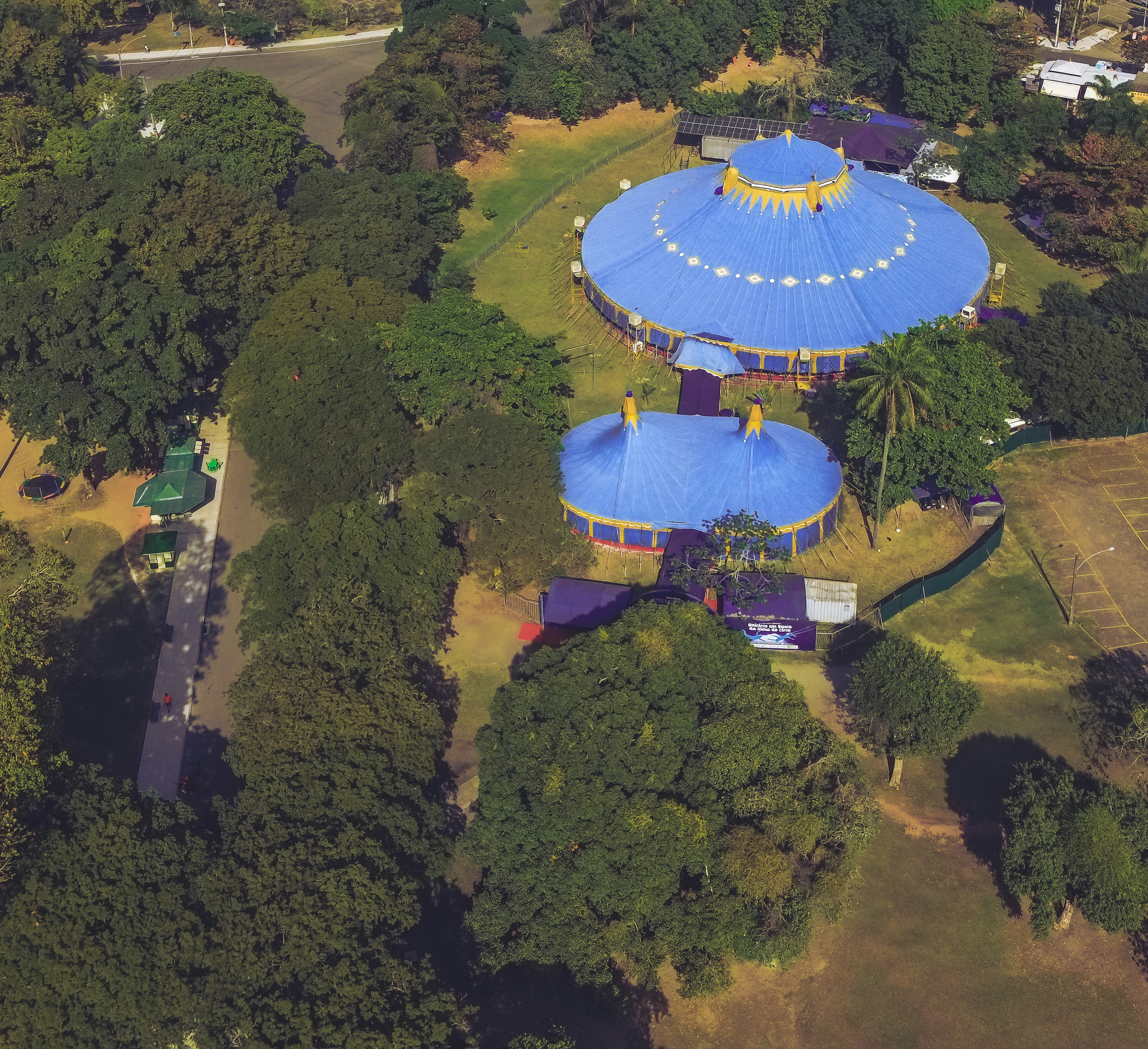 an aerial view of a blue and yellow structure surrounded by trees