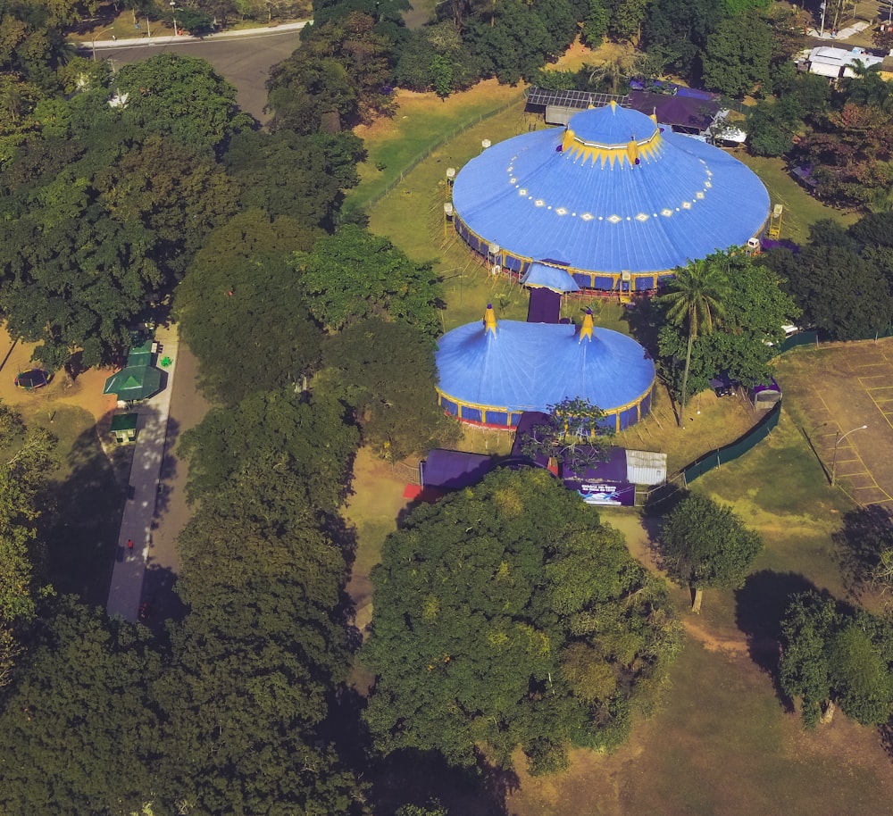 an aerial view of a blue and yellow structure surrounded by trees