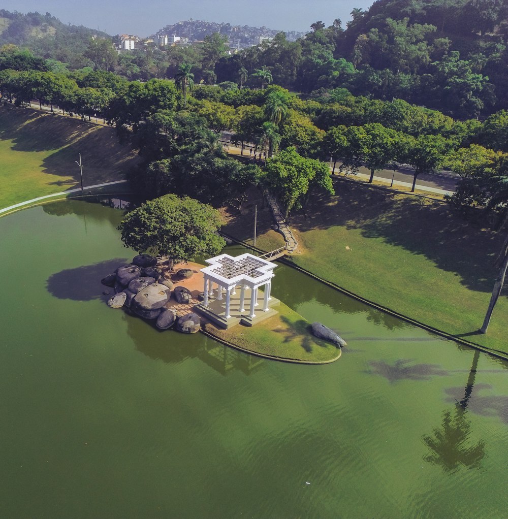 an aerial view of a small white structure in the middle of a lake