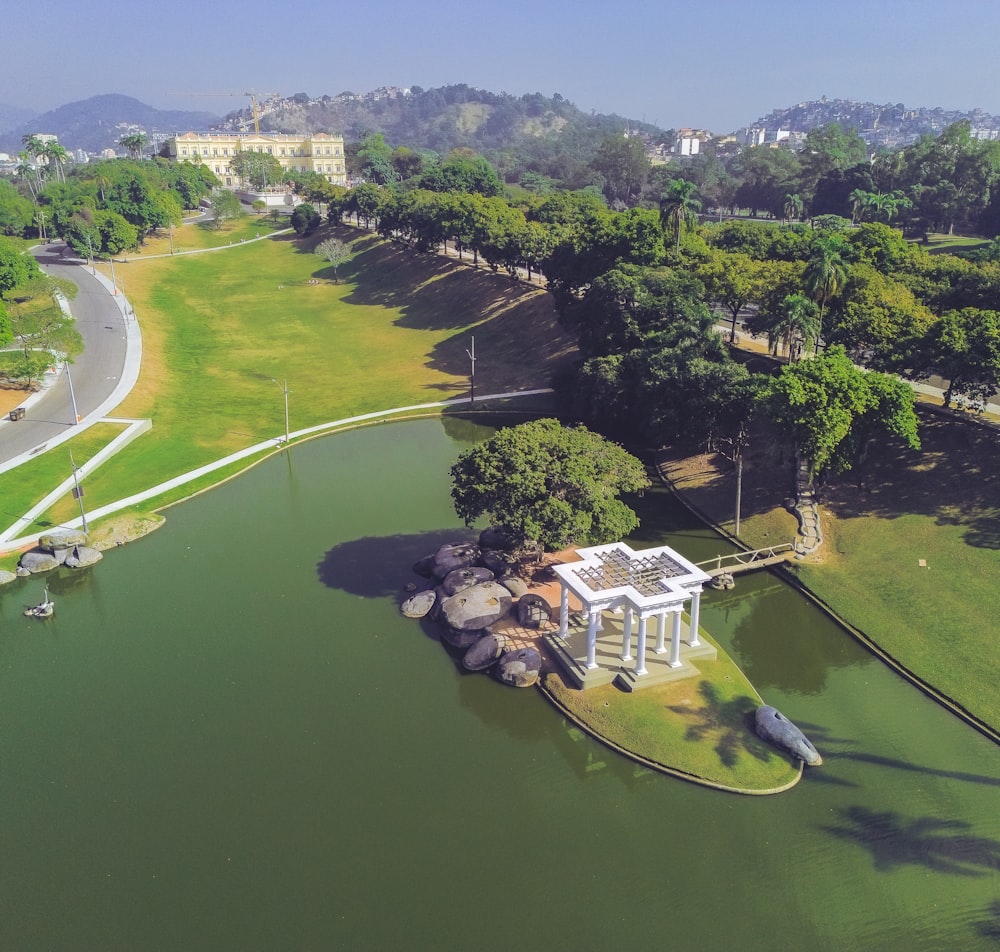 an aerial view of a park with a pond and pavilion