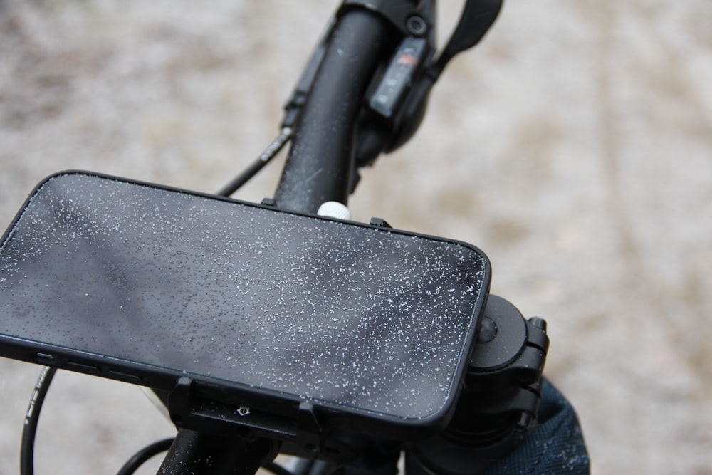Un primer plano de un teléfono celular en el manillar de una bicicleta