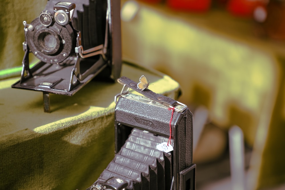 a couple of old cameras sitting on top of a table