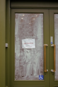 a green door with a sign taped to it