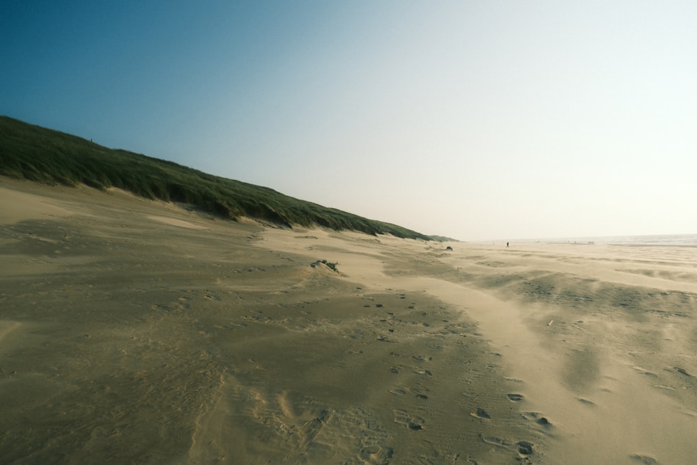 a sandy beach with footprints in the sand