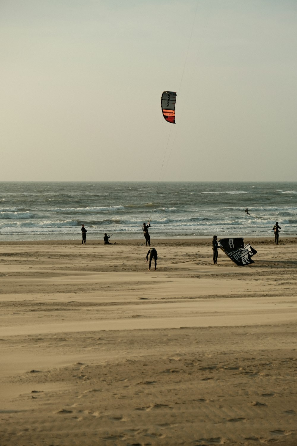 a group of people standing on top of a sandy beach