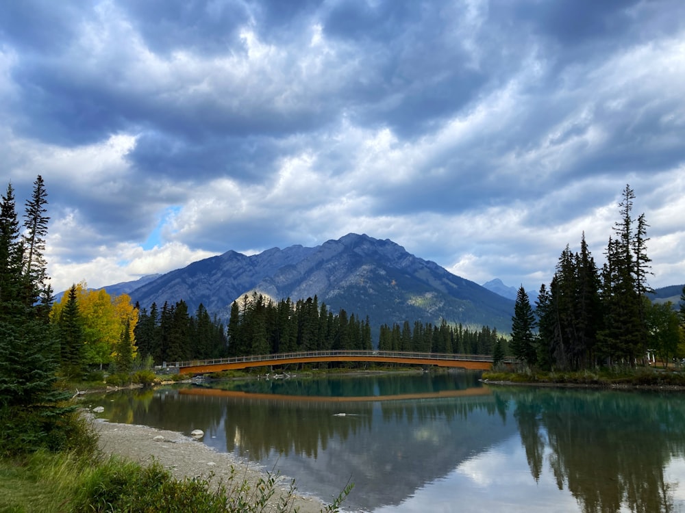 a bridge over a lake with a mountain in the background