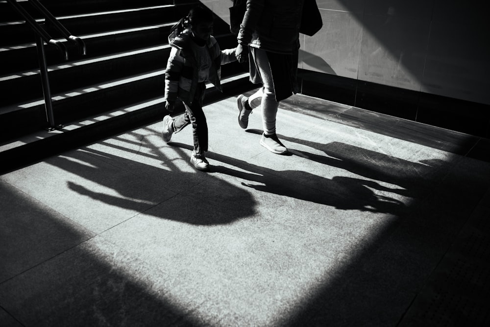 a couple of people walking down a sidewalk