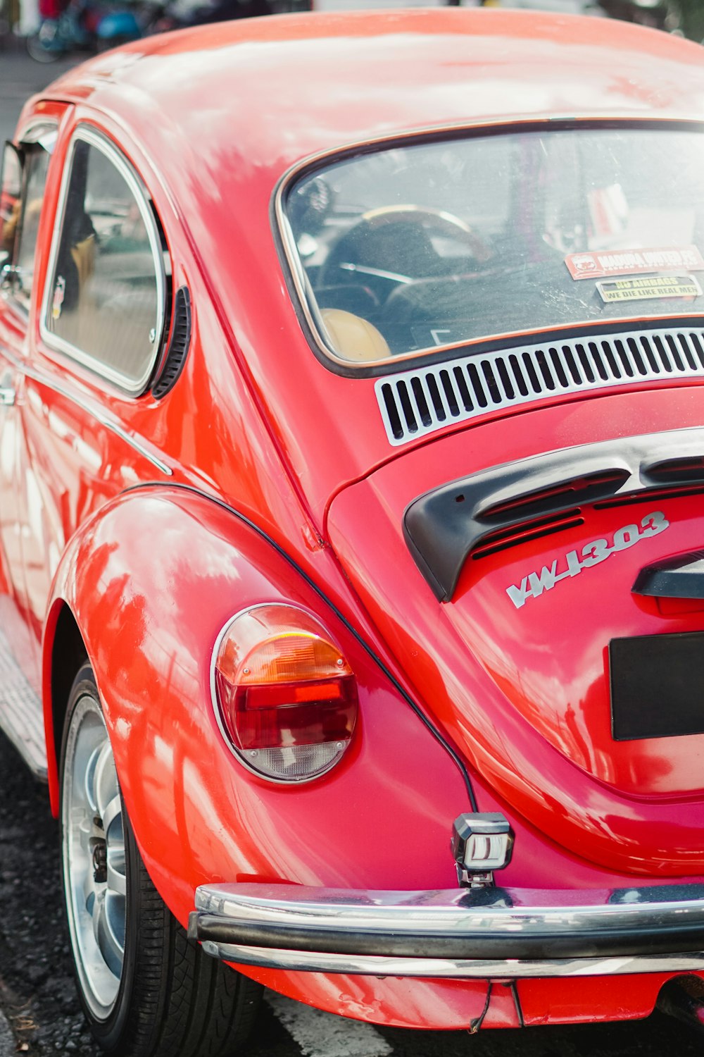 a red vw bug parked in a parking lot