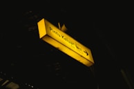a yellow street sign hanging from the side of a building