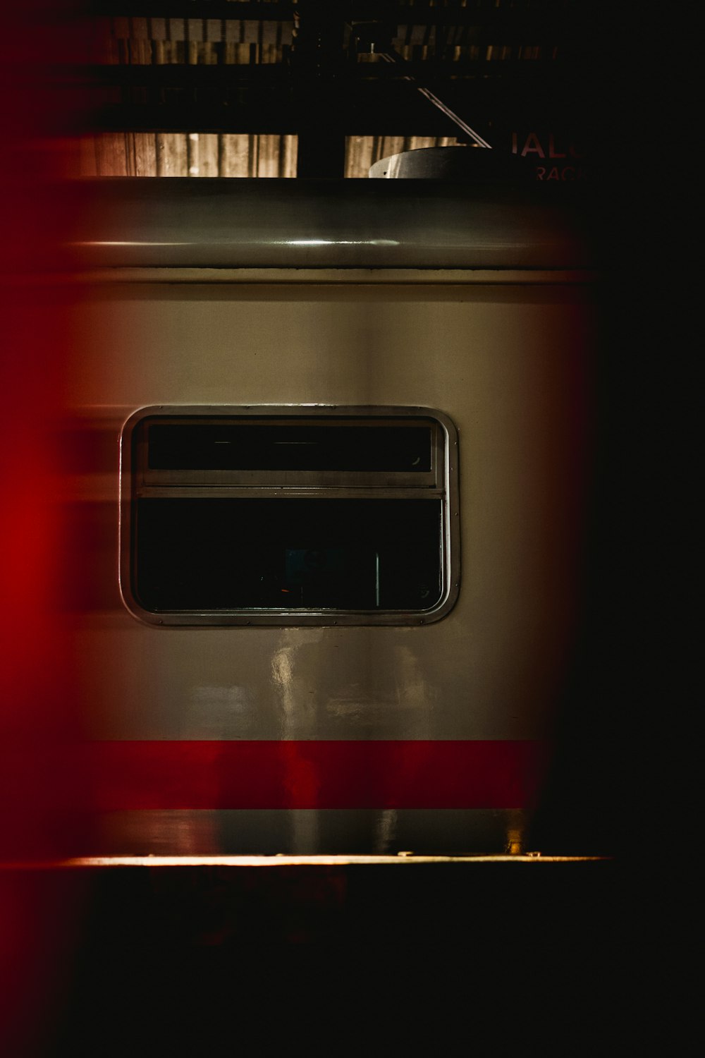 a red and white train traveling through a train station