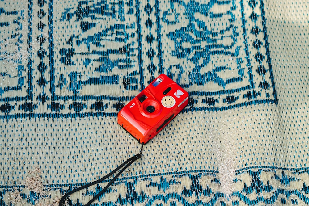 a red camera sitting on top of a blue rug