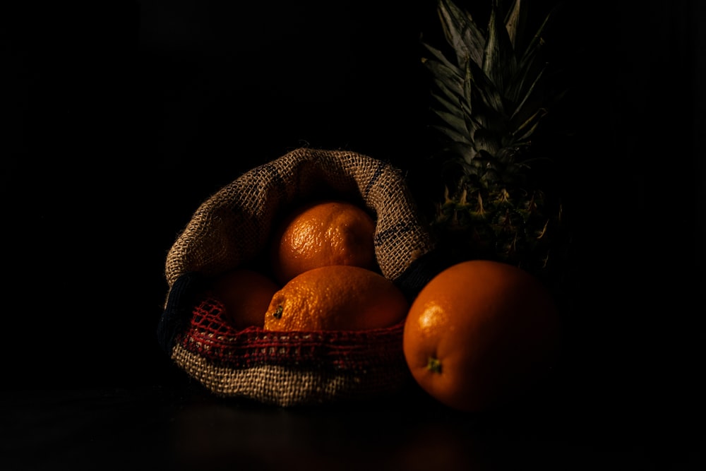 a bag of oranges and a pineapple on a table