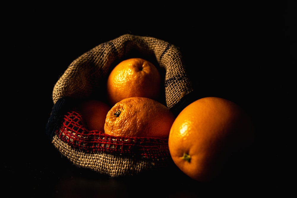 a basket filled with oranges sitting on top of a table