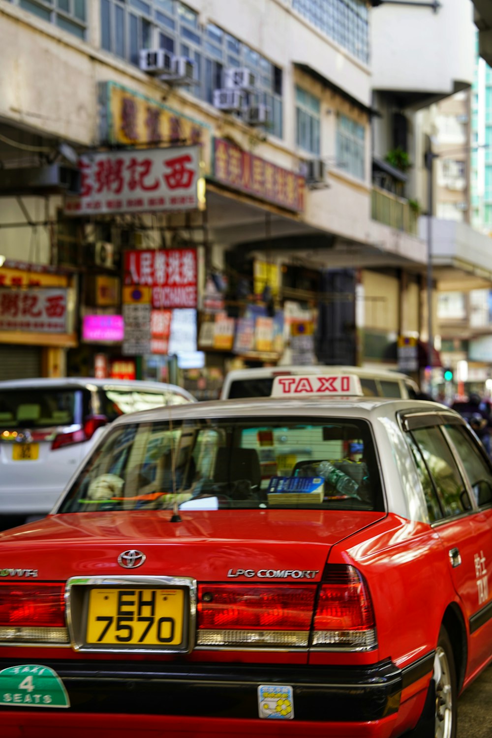 a red taxi cab parked on the side of a street