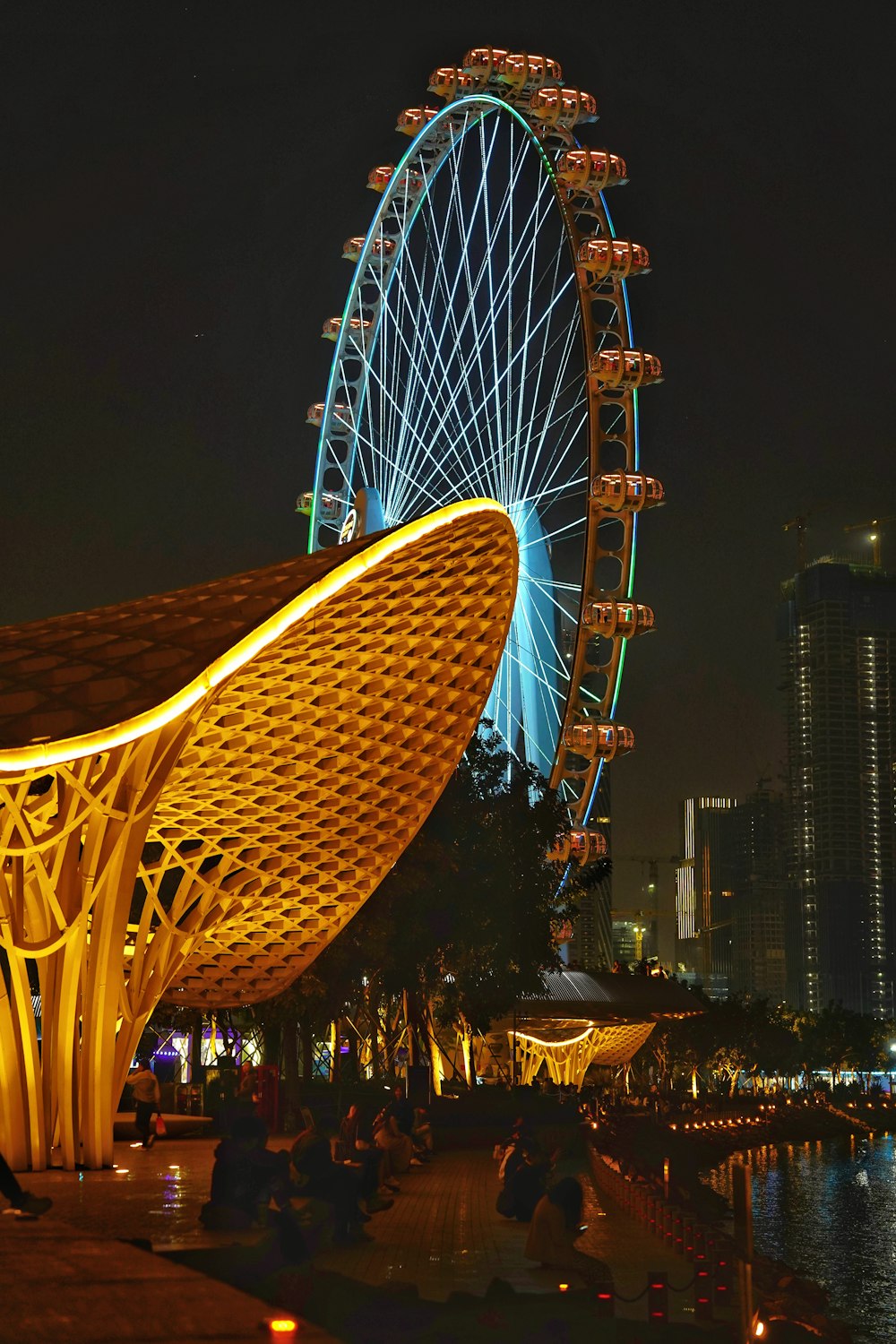 a large ferris wheel sitting next to a body of water