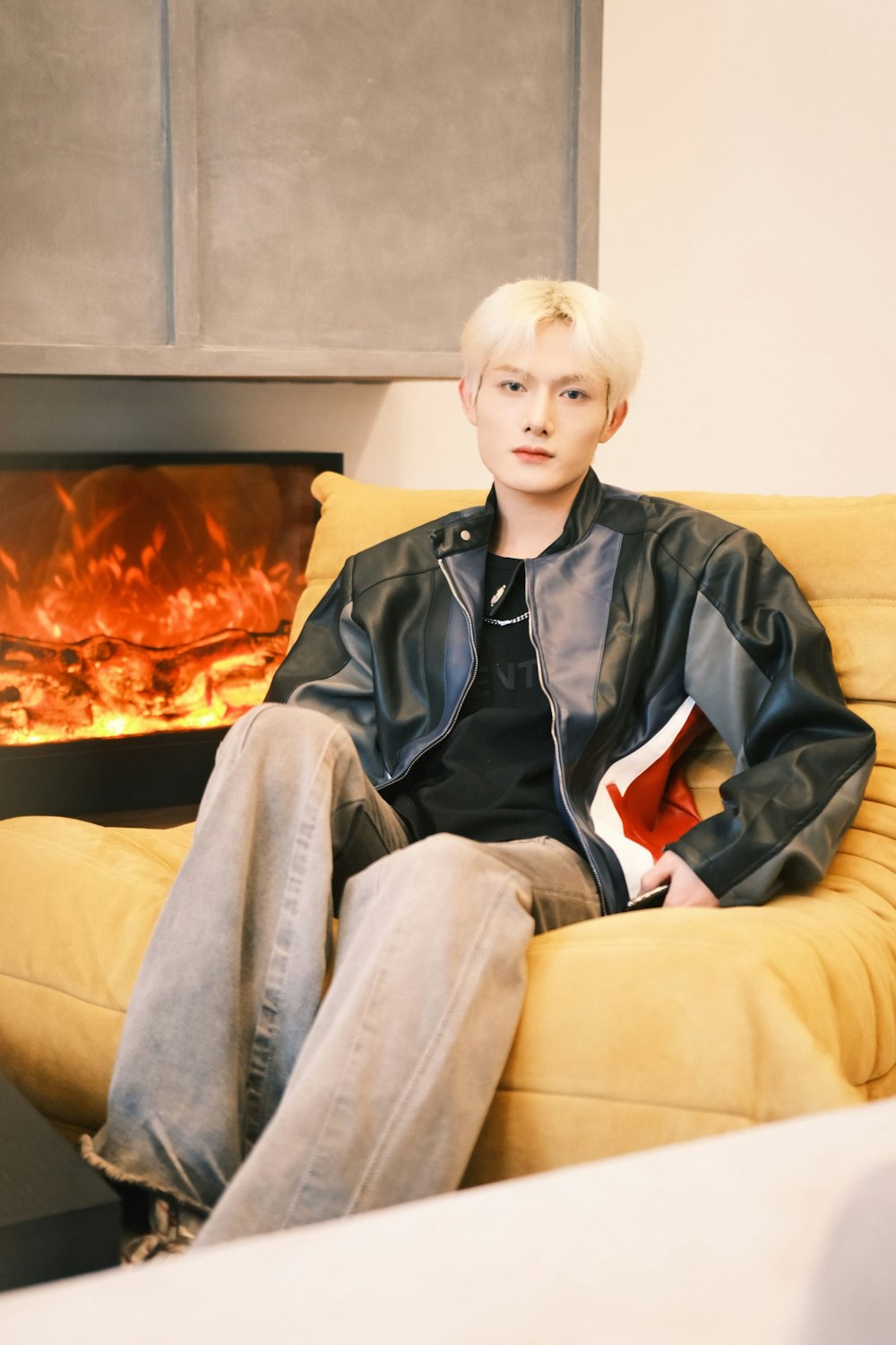 a man sitting on a couch in front of a fireplace