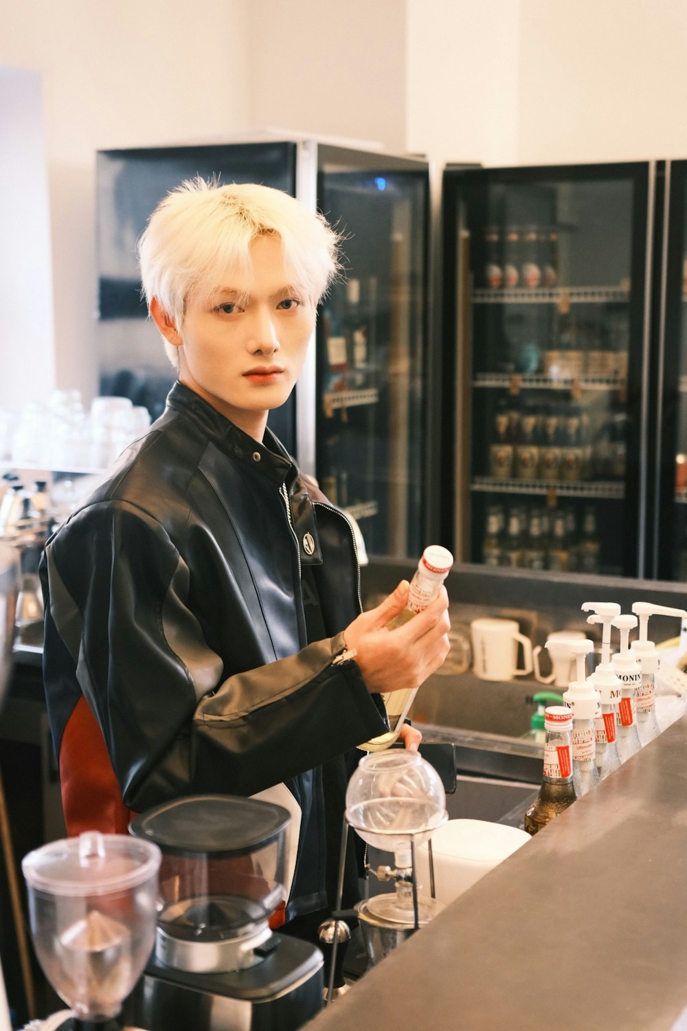 a man with white hair standing at a counter