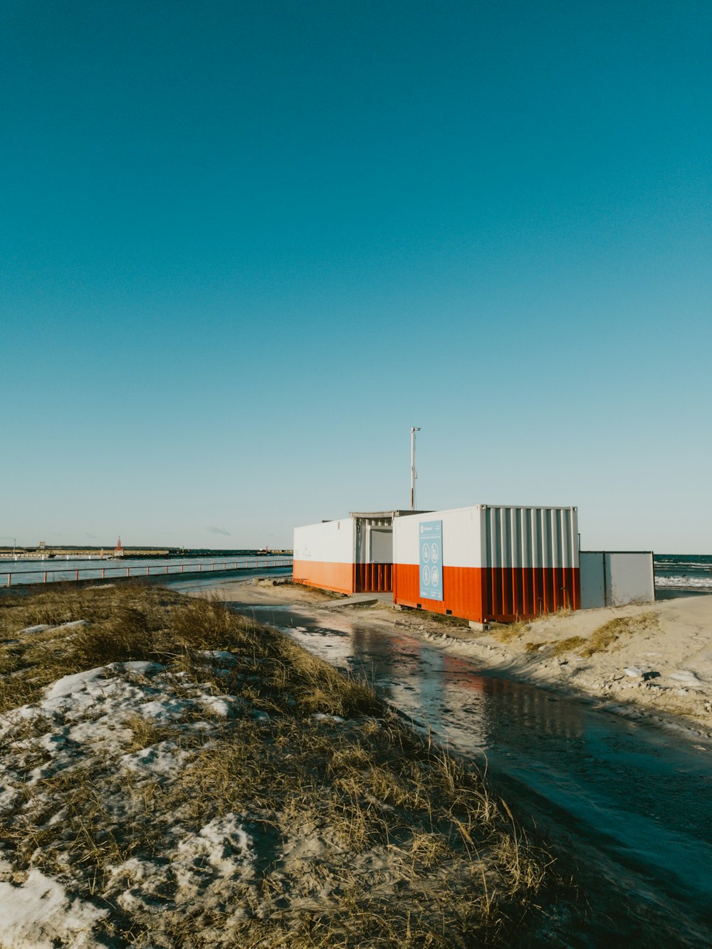 a couple of buildings sitting on top of a sandy beach