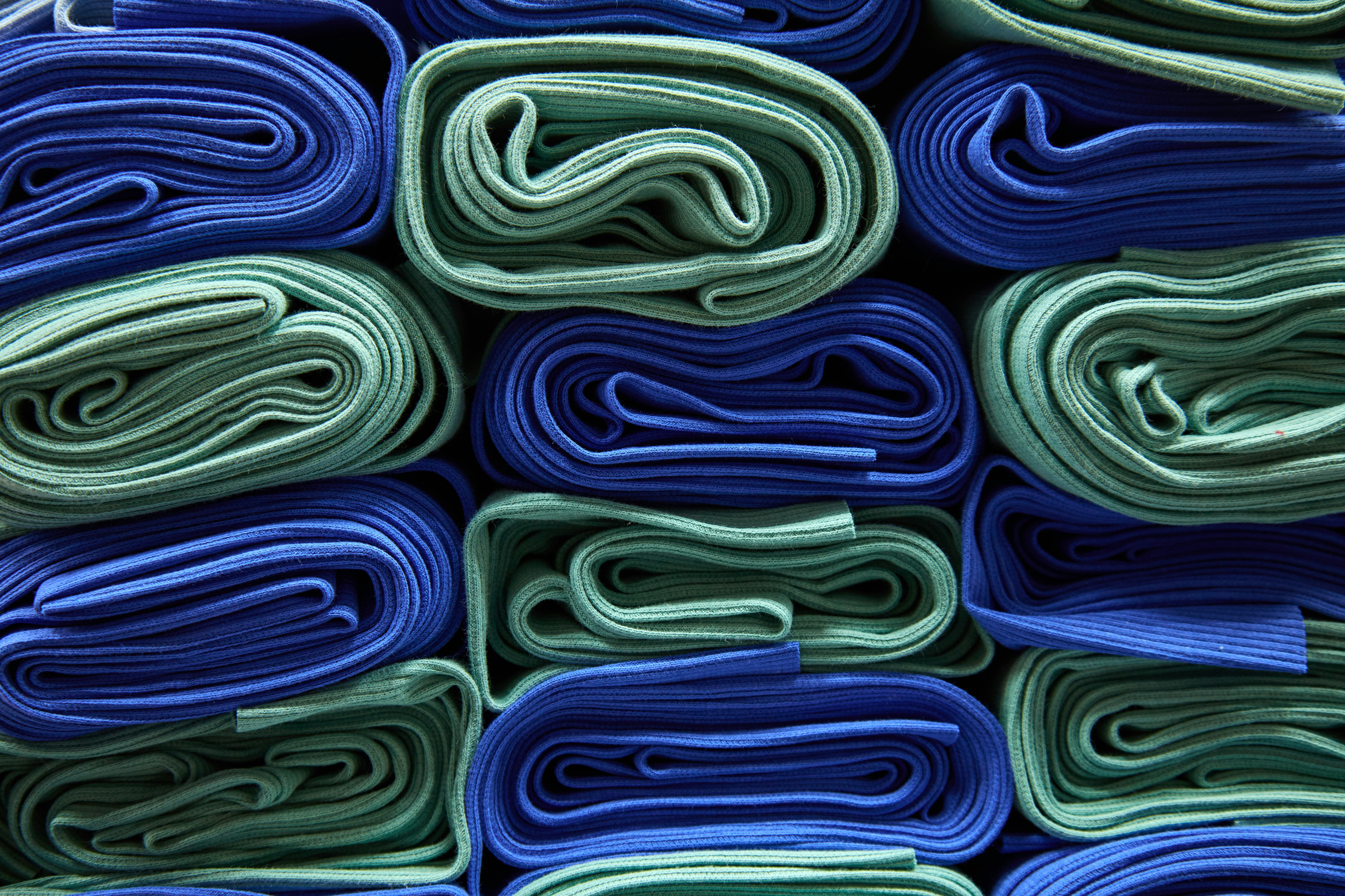 a pile of folded blue and green cloths