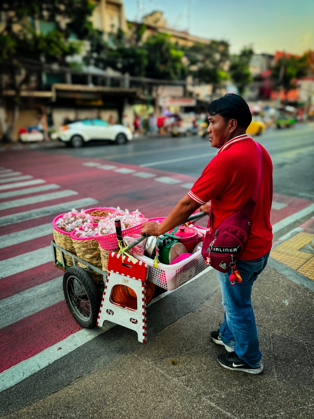 a man pushing a cart full of food down a street