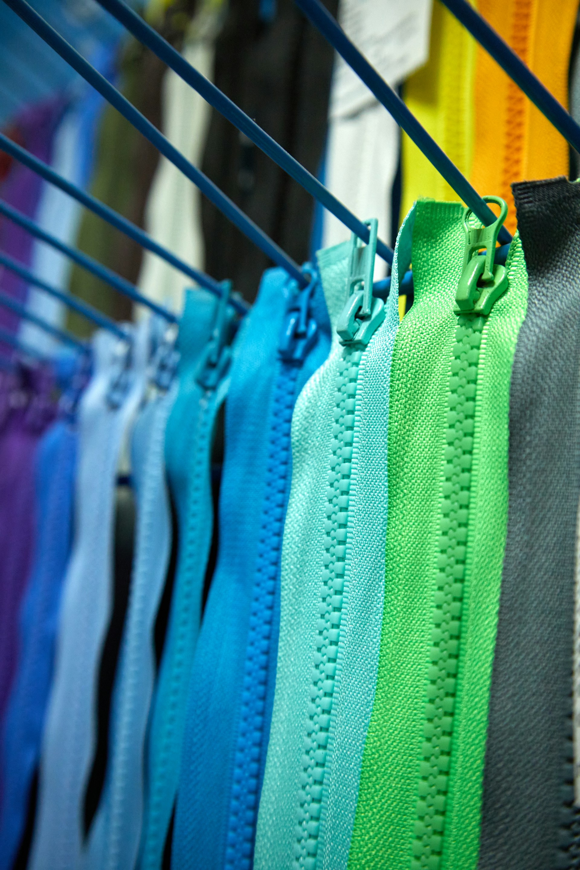 a row of colorful zippers hanging on a clothes line