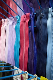 a bunch of colorful zippers hanging on a rack