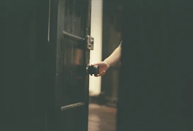 a person opening a door with their hand