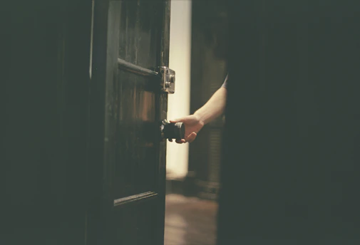 a person opening a door with their hand