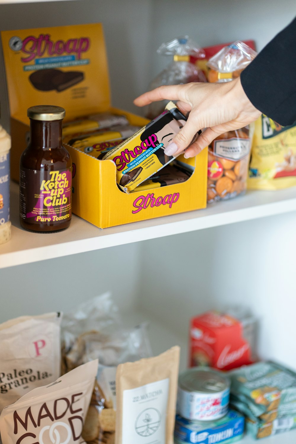 a person reaching for a bag of food on a shelf