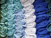 a bunch of folded cloths are stacked on top of each other
