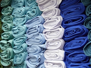a bunch of folded cloths are stacked on top of each other