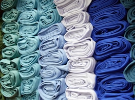 a bunch of folded cloths are stacked on top of each other