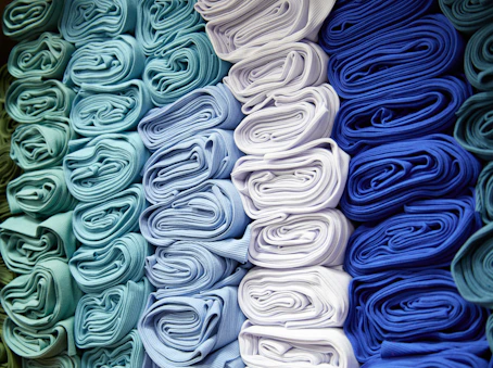 a bunch of folded cloths are stacked on top of each other