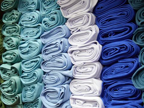 Telas dobladas y apiladas en tonos azules y blancos