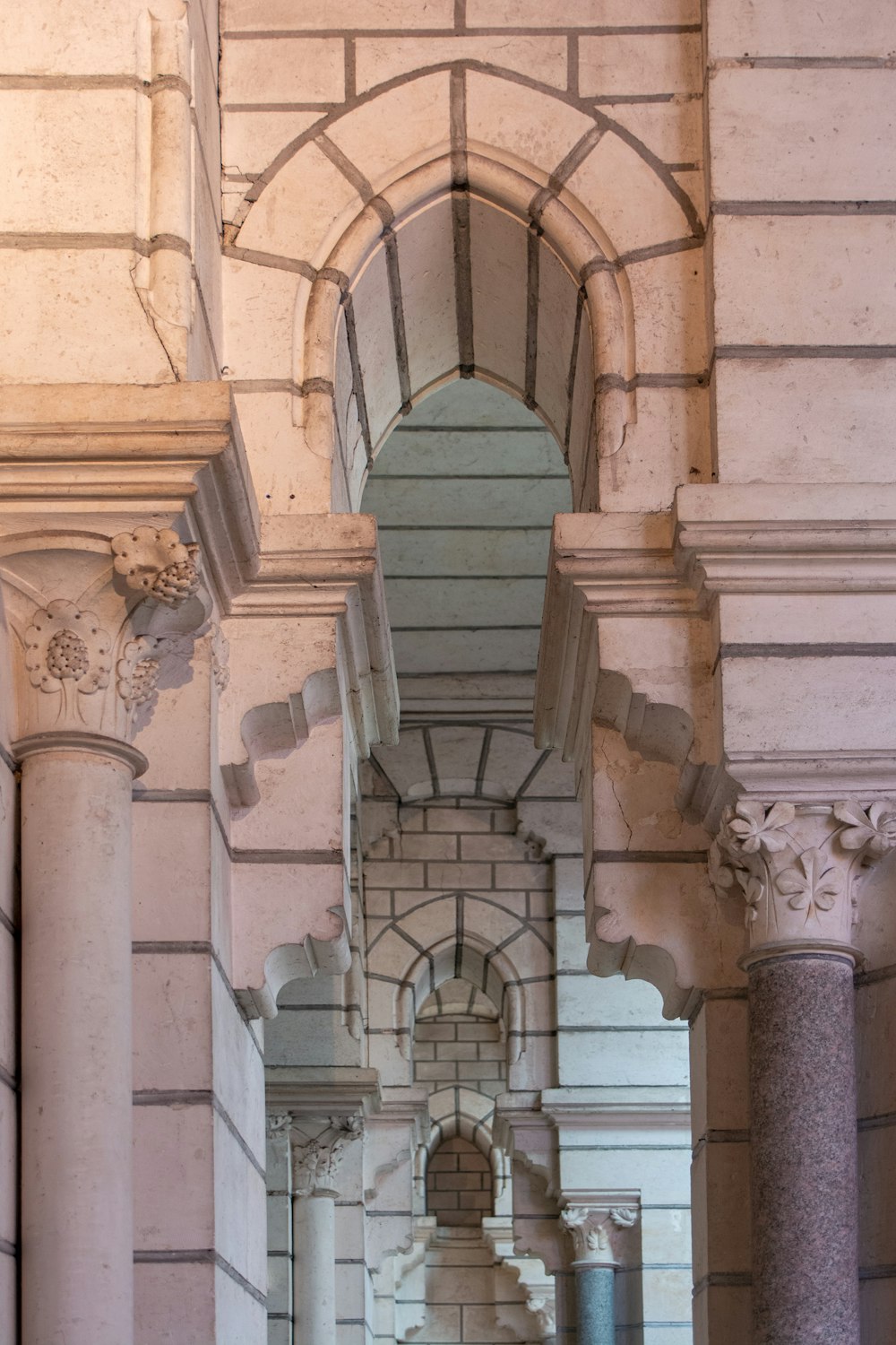 an archway between two stone pillars in a building